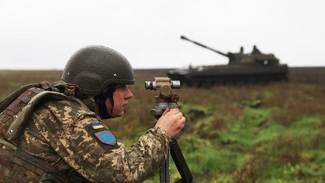 A Ukrainian soldier aims before a 2S1 Gvozdika tank fires a shell on the front line in Donetsk region on October 10, 2022 as Russian forces launched earlier today at least 75 missiles at Ukraine, with fatal strikes targeting the capital Kyiv, and cities in the south and west. (Photo by Anatolii STEPANOV / AFP)