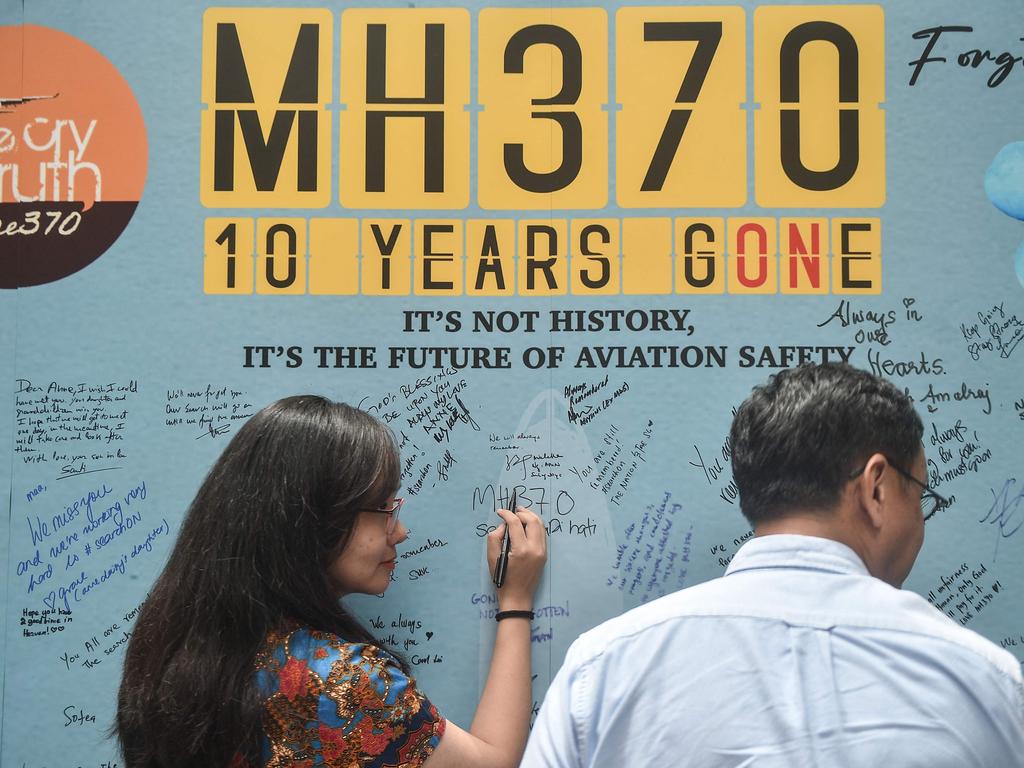 A woman writes a message during an event held by relatives of the passengers and supporters. Picture: Arif Kartono / AFP)