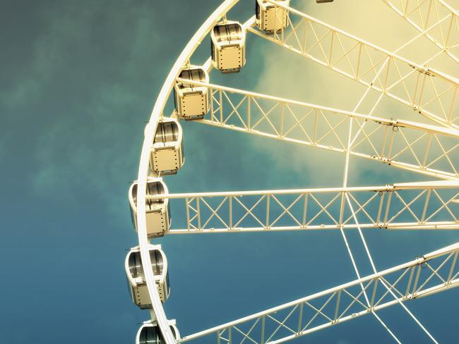 Retro style image of a ferris wheel against blue sky. Cross-processed, old instant photo effect.