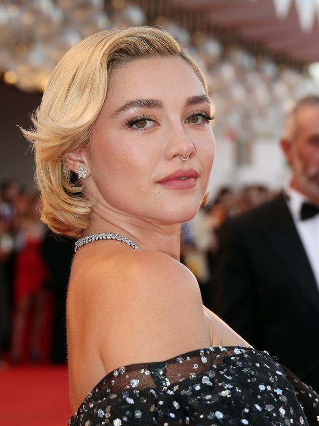 Film lead Florence Pugh walks the premiere red carpet.