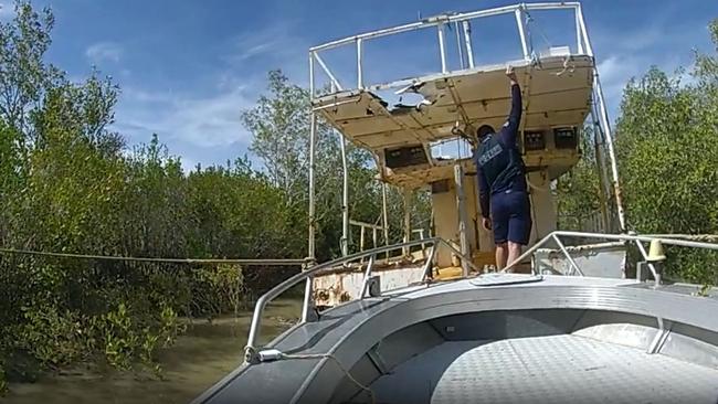 Police officers search a boat in connection with the arrest of a 47-year-old Karumba man who they later charged with torture and slavery. Picture: Queensland Police