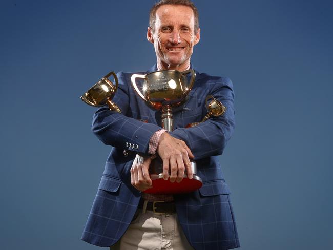 MELBOURNE , AUSTRALIA. October 29, 2023.  Champion jockey Damien Oliver with the 3 Melbourne Cups he has won on Doriemus (1995), Media Puzzle (2002) and Fiorente (2013) near his home in Port Melbourne.      . Pic: Michael Klein