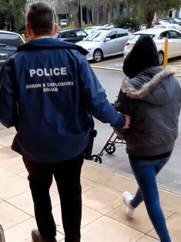 A woman is arrested in Flemington after a string of alleged arson attacks on tobacco shops in Melbourne's west. Picture: Victoria Police