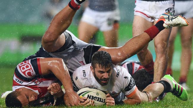 James Tedesco scores a try against Kane Evans of the Roosters.