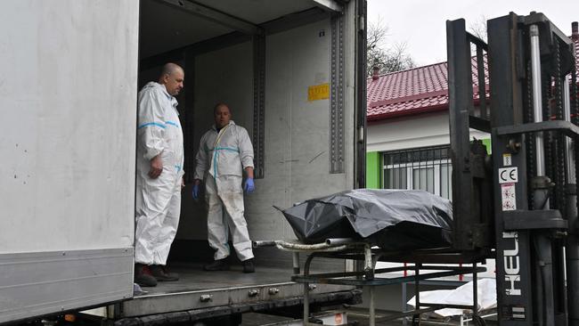 An exhumed body is loaded into a refrigerated truck at a mortuary in Bucha last week. Picture: AFP