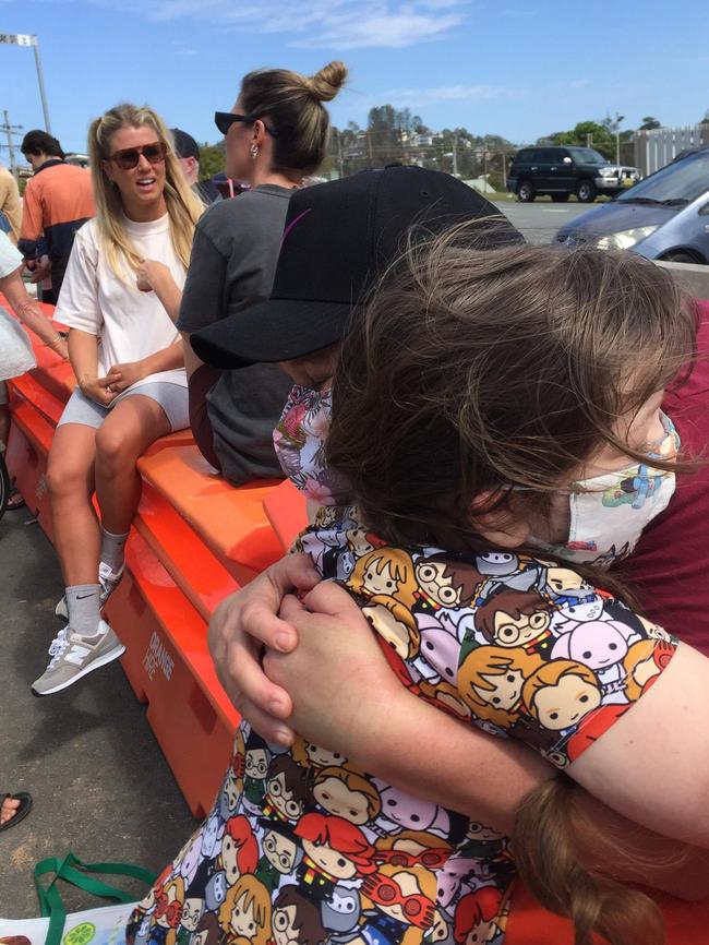 Bonnie, 8, embraces parents Boyd and Kathy McNamara across the border.