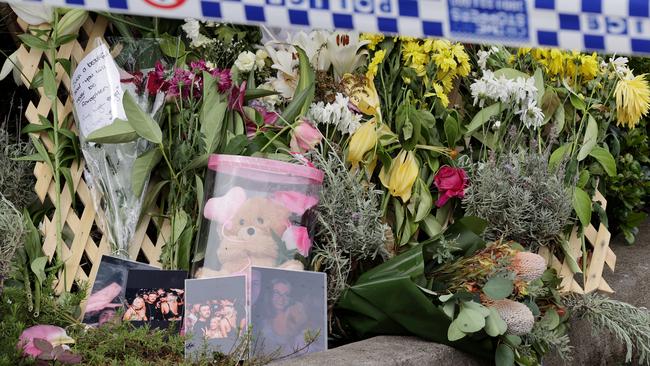 Photos and flowers have been left at the unit block where Mackenzie Anderson was stabbed to death. Picture: Toby Zerna