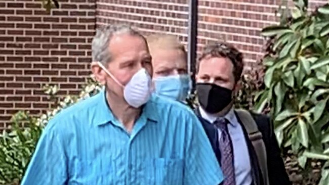 Brenton Lowe (middle, back) hides behind man who appears to be his father (left) and lawyer (right). Picture: Madelaine Wong