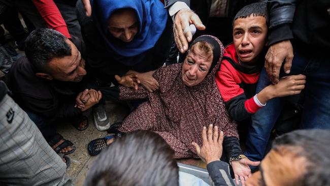 People mourn beside the bodies of friends and relatives killed in an air strike on December 25. Picture: Ahmad Hasaballah/Getty Images