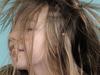 Generic image of young girl drying her blonde hair with electric hairdryer.