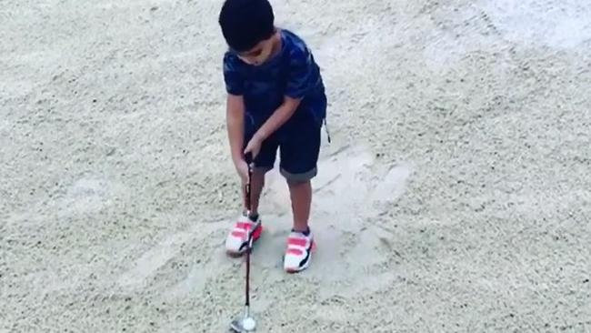 Jason Day's 5-year-old son Dash about to hit his bunker shot in a still taken from Jason Day’s Instagram post.