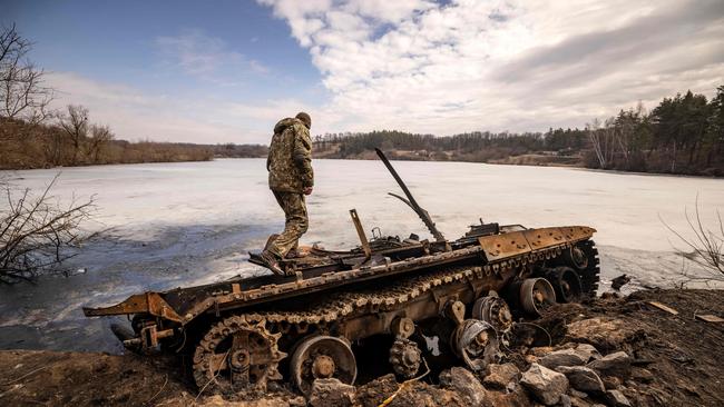 A Ukrainian serviceman stands near a destroyed Russian tank in the northeastern city of Trostianets, on March 29, 2022. Picture: Fadel Senna/AFP