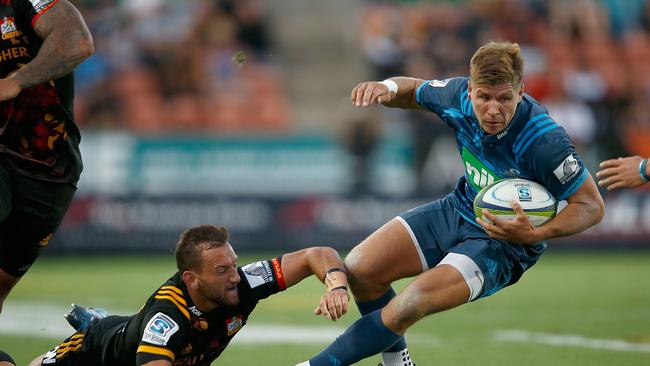 Piers Francis of the Blues is tackled by Aaron Cruden of the Chiefs.