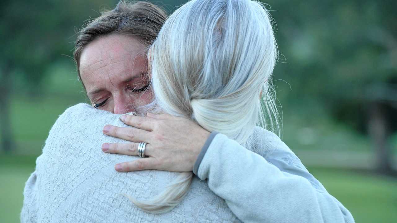 Theo's mother, Vinciane Delforge, comforted by community members as Theo's father Laurent Hayez prepares to address media at the Byron Bay Golf Course. Picture: Marc Stapelberg