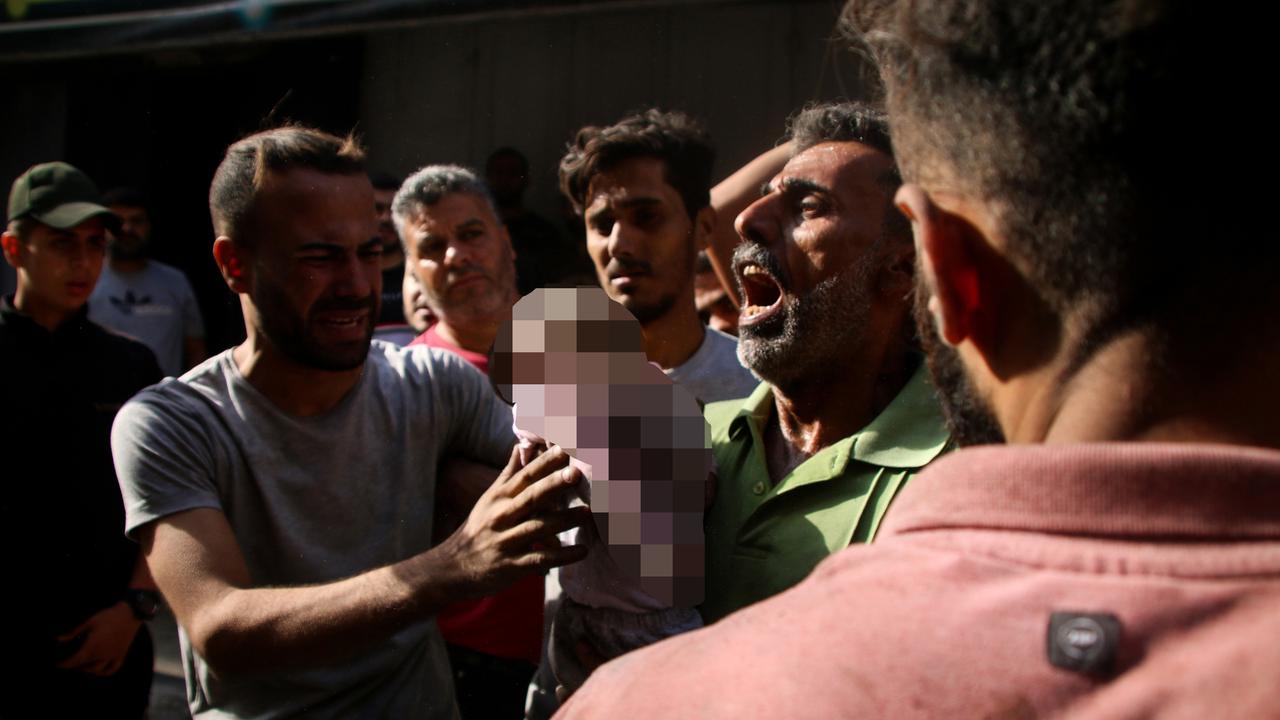 A Palestinian man carries his dead baby. Picture: Getty