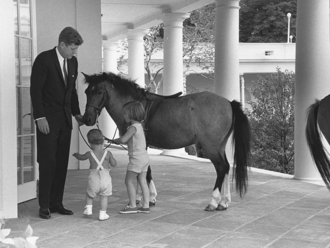 Outside the White House's Oval Office, American President John F. Kennedy and his children, John and Caroline, play with pony Macaroni, on June 22, 1962. Picture: Getty Images