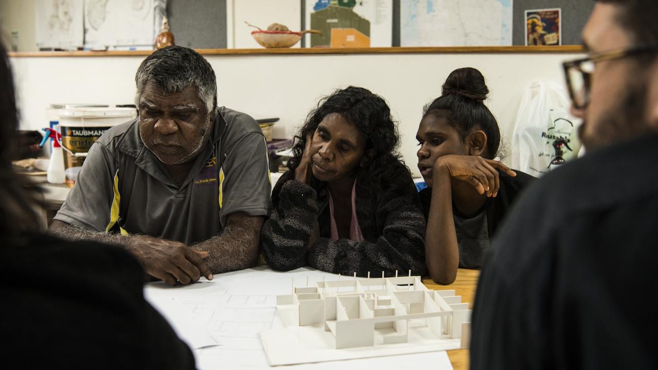 Tennant Creek resident Norm Frank Jupururrla, his wife Serena Morton Nabanunga and daughter look at a cardboard model of a preliminary house designed for the Wilya Junta (Standing Strong) Housing Collaboration. Picture: Supplied/Andrew Quilty.