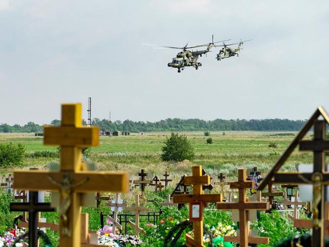 Russian military helicopters painted with the letter Z, a tactical insignia of Russian troops in Ukraine, are seen flying behind a cemetery near a military airfield outside the Rostov region. Picture: AFP