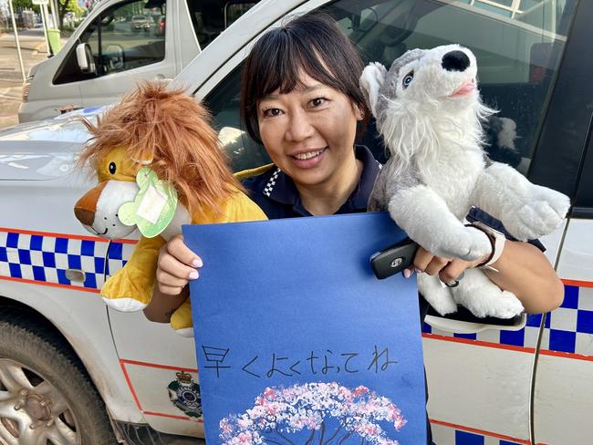 Cross-Cultural Senior Police Liaison Officer Kayko Berry presented a young Japanese boy who was allegedly stuck in the head in a rock throwing incident on Kuranda Scenic Rail, with two stuffed animals made by St Joseph's Outside Hours School Care. Photo: QPS.