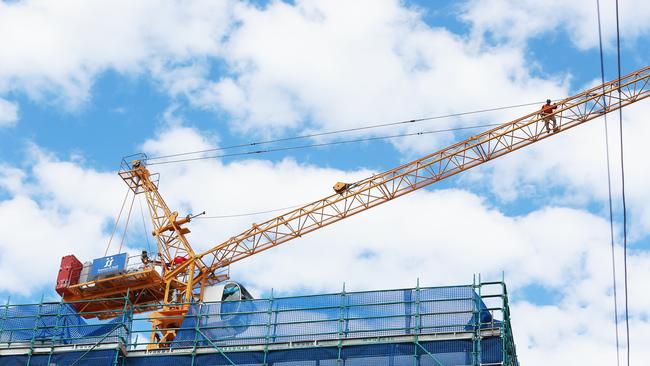 A crane worker stands on the boom above Citro apartments on Victoria Street, West End. Work has ceased on the construction site while the developer looks for a builder after the collapse of Sommer and Staff. Picture: AAP Image/no byline