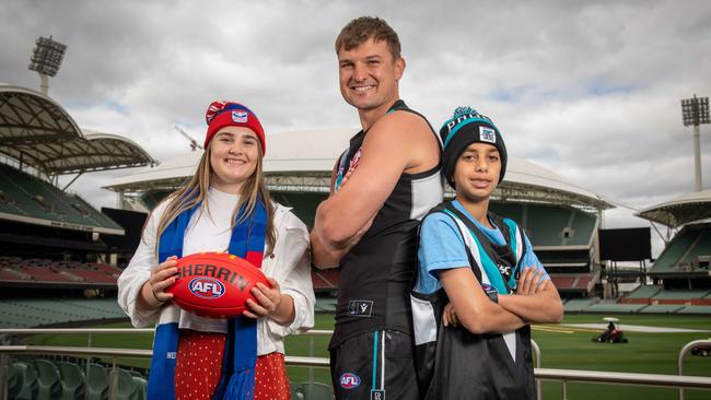 Port Adelaide star Ollie Wines with football fans Matilda and Zayd El-Hosni. Picture: NCA NewsWire/Naomi Jellicoe