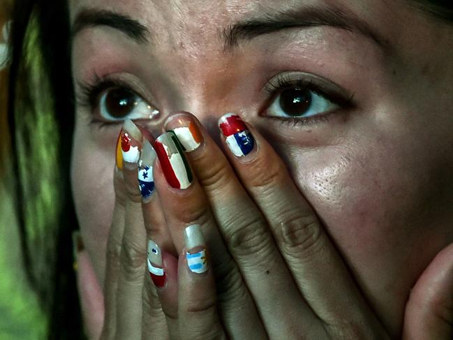 TOPSHOTS Brazil's fan reacts during a public viewing event at a street in Rio de Janeiro during the 2014 FIFA World Cup semifinal match Brazil vs Germany --being held at Mineirao Stadium in Belo Horizonte-- on July 8, 2014. AFP PHOTO / YASUYOSHI CHIBA