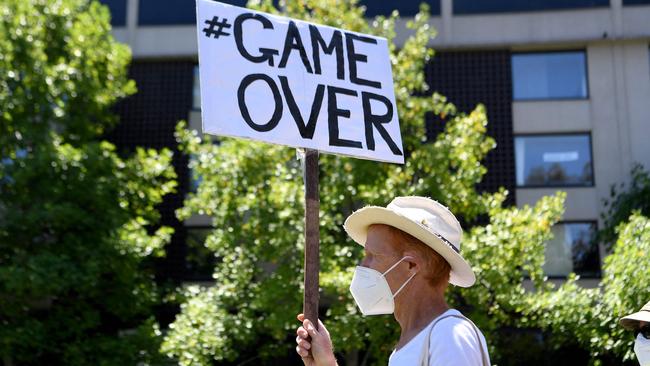 An activist holds a placard during a rally outside a government detention centre where Novak Djokovic is staying. Picture: AFP