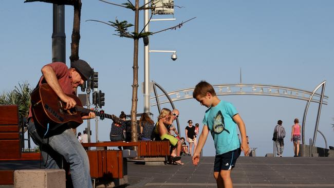 Gold Coast Bulletin journalist experiences 24 hours in the life of Surfers Paradise. Busker Bud Manthey entertains the Cavill Mall crowd and receives a coin donation from a young fan . Picture by Scott Fletcher