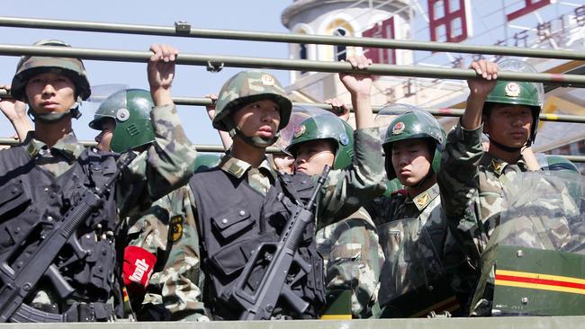 Paramilitary police officers patrol on a track near the Grand Bazaar in Urumqi, western China's Xinjiang province in 2009. Picture: AP/Eugene Hoshiko)