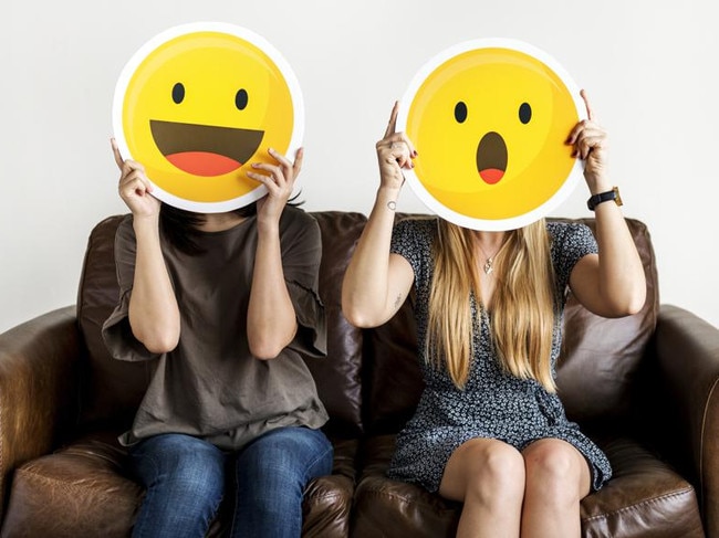 Interracial women holding an expressive emoticon face surprised and happy facial expression social media and chat concept ***These graphics are derived from our own 3D generic designs. They do not infringe on any copyright design.