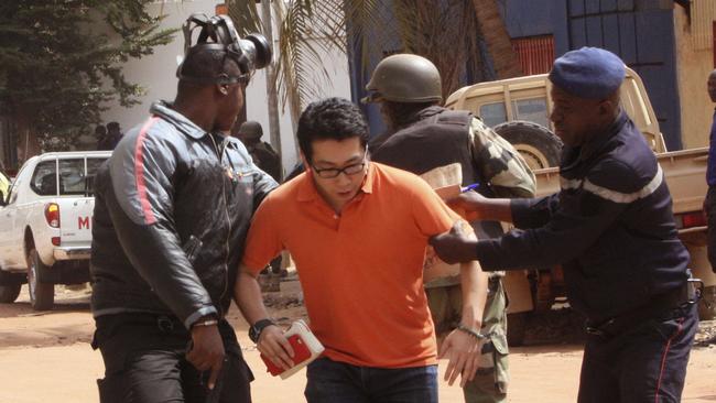 Mali troops help a hostage as he fled the Radisson Blu hotel which was attacked by al-Qaeda in what experts believe was carried out in response to the Paris attacks. Picture: AP Photo/Harouna Traore.