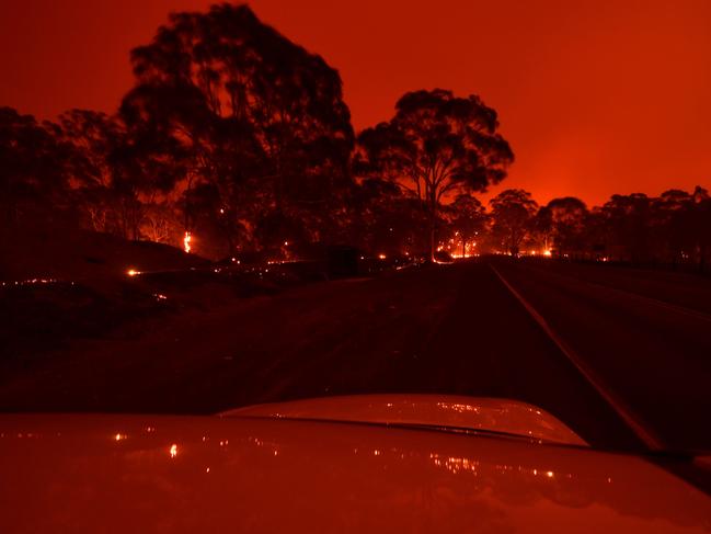 The afternoon sky glows orange from bushfires in the area around the town of Nowra in the Australian state of New South Wales on December 31, 2019. - Thousands of holidaymakers and locals were forced to flee to beaches in fire-ravaged southeast Australia on December 31, as blazes ripped through popular tourist areas leaving no escape by land. Picture: Saeed Khan/AFP