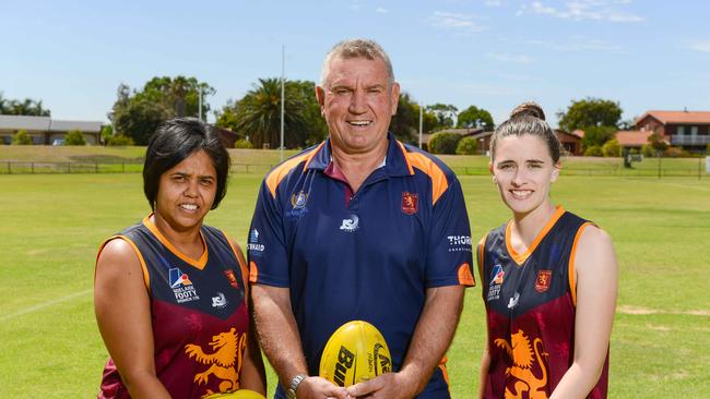 Adelaide Footy League women's division one players Bronwyn Davey, left and Remy Grant with Port Adelaide great and Lions’ coach Greg Phillips before the 2019 season started. Picture: AAP/Brenton Edwards