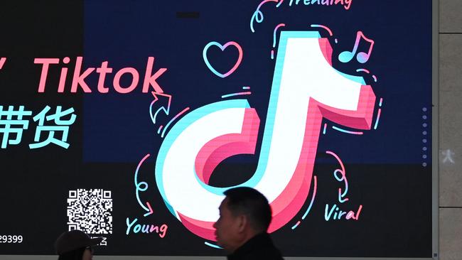 People walk past an advertisement featuring the TikTok logo at a train station in Zhengzhou, in Chinaâs central Henan province on January 21, 2024. China on March 14, 2024 slammed the approval of a US bill that would ban TikTok unless it severs ties with its Chinese parent company, blasting Washington's "bandit" mentality and vowing Beijing would "take all necessary measures" to protect the interests of its companies overseas. (Photo by GREG BAKER / AFP)