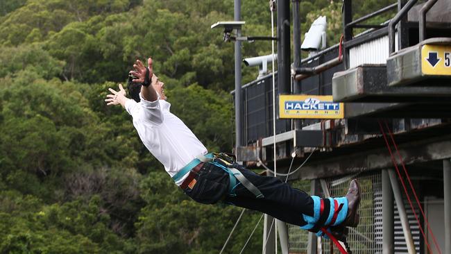 Tourism Tropical North Queensland chief executive Mark Olsen bungy jumps from the AJ Hackett tower at Smithfield, with the help of Jumpmaster Luke Major. PICTURE: BRENDAN RADKE