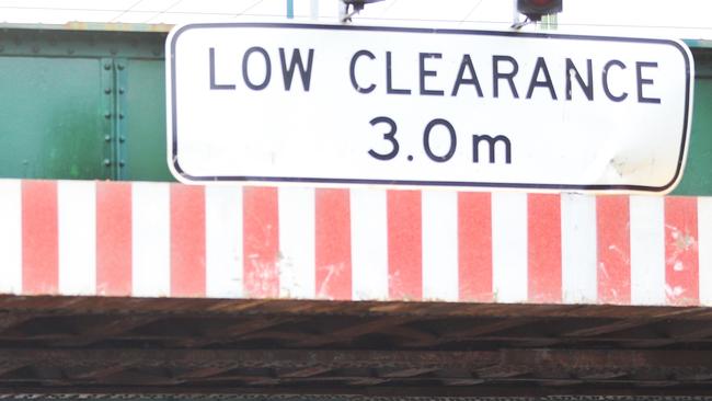 The ‘low clearance’ sign and red and white warning panel on the Montague St bridge. Picture: Hamish Blair