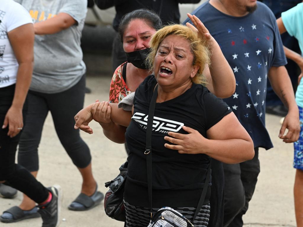 The mother of one of the inmates at the prison is overcome with emotion as other families await news outside the facility. (Photo by Orlando SIERRA / AFP)