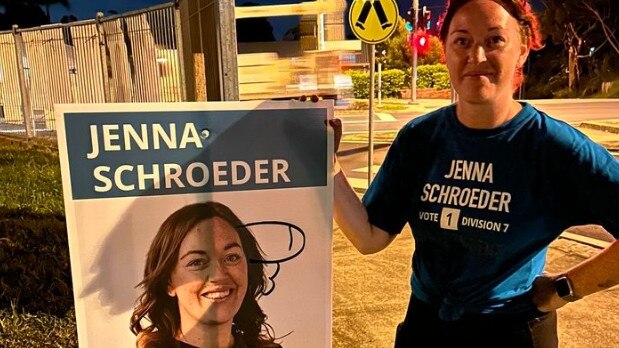 Division 7 candidate Jenna Schroeder inspecting damage to her corflutes after vandals struck during the 2024 Gold Coast City Council election.