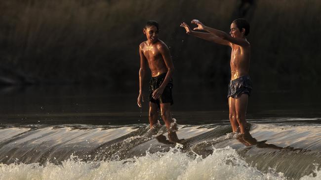 Boys standing on Brewarrina Weir in northern NSW. Picture: Mark Evans/Getty Images