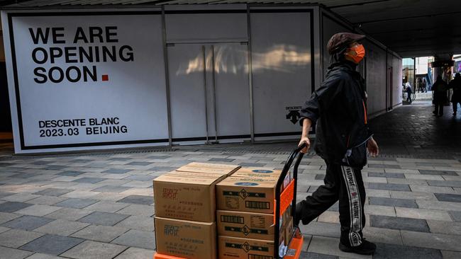 A woman hauls a cart of goods at a shopping mall in Beijing. Picture: AFP