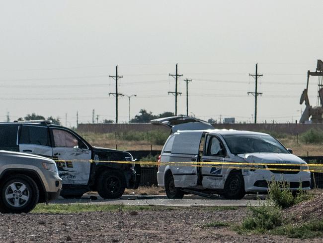 A damaged police vehicle and a post office van blocked off with tape nearby to where a gunman was shot and killed. Picture: Getty Images/AFP