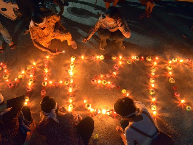 Cambodian residents of a community light candles as they pray for the missing Malaysia Airlines flight MH370. Picture: Tang Chhin Sothy