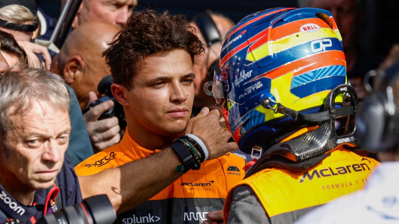 McLaren's British driver Lando Norris (CL) shakes hands with McLaren's Australian driver Oscar Piastri after the qualifying session at The Circuit Zandvoort, ahead of the Dutch Formula One Grand Prix, in Zandvoort on August 26, 2023. (Photo by SIMON WOHLFAHRT / AFP)