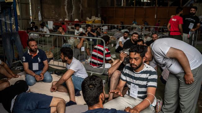 Survivors sat inside a warehouse at the port in Kalamata town on June 15. Picture: Angelos Tzortzinis / AFP