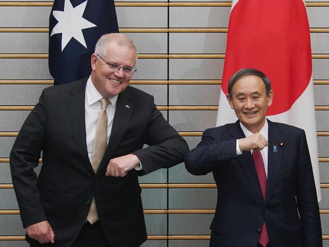 Australia's Prime Minister Scott Morrison (L) and Japan's Prime Minister Yoshihide Suga (R) bump elbows as they pose at the start of their bilateral meeting at Suga's official residence in Tokyo on November 17, 2020. (Photo by Eugene Hoshiko / POOL / AFP)