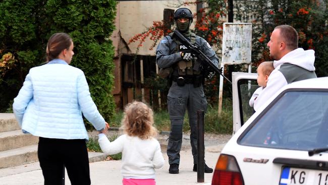 Pedestrians walk as Kosovo police officers search a restaurant and building in northern Serb-dominated part of ethnically divided town of Mitrovica on September 29, 2023. Picture: STRINGER / AFP