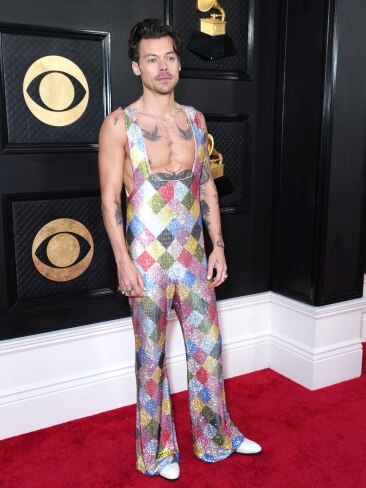 Heartthrob Harry Styles rocked the red carpet in an eye-catching rainbow jumpsuit embellished with Swarovski crystals. Picture: Kevin Mazur/Getty Images for The Recording Academy