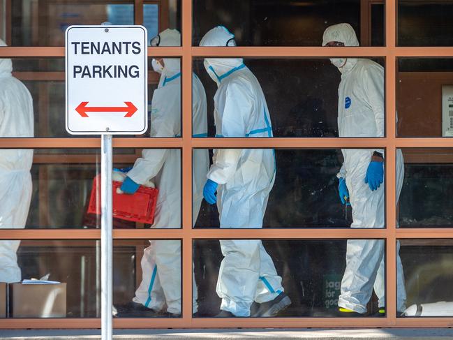 Health workers deliver food to locked-down residents. Picture: Jake Nowakowski