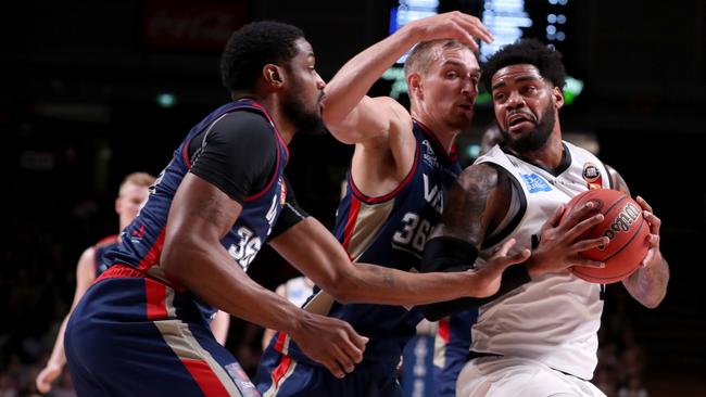 Ramone Moore and Anthony Drimic of the Sixers defending Melbourne’s DJ Kennedy. Picture: AAP