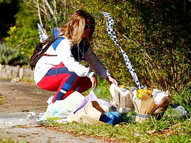 A woman places flowers at the site of a makeshift memorial for Jack and Jennifer Edwards. Picture: AAP/Jeremy Ng